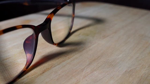 Pair of eyeglasses isolated on wooden table indoors 