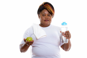 Studio shot of fat black African woman holding water bottle and 