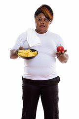 Studio shot of fat black African woman standing while holding bo