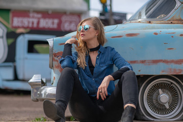 Girl sittin on a Rusty old blue car