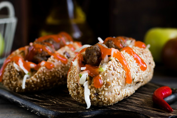 Spicy hot dog with meatballs with apple and cabbage garnish