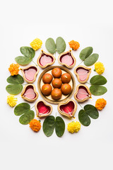 Happy Dussehra / Vijayadashami / Ayudh Puja greeting card using apta/Bauhinia racemosa/Bidi leaf and indian sweet Rasgulla or Gulab Jamun for Navaratri along with Diya/oil lamp