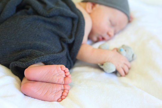 newborn baby sleeping in the arms of a toy