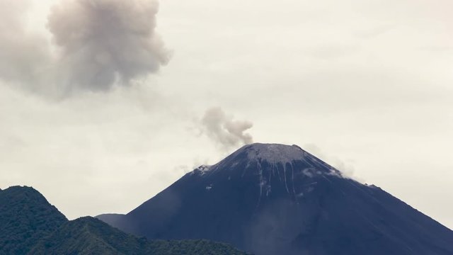 Reventador Volcano erupting, November 2015. The mountain is situated in a remote part of the Ecuadorian Amazon. The rainforest covered slopes in foreground are part of the caldera. Time-lapse.