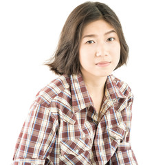 Young woman in a plaid shirt posing in studio on white