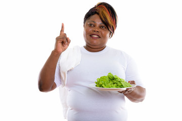 Thoughtful happy fat black African woman smiling while holding l