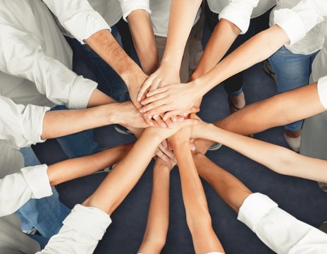 Handshake of many young business people, teamwork