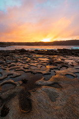 Obraz premium Warm sunrise light on the rocky coastline.