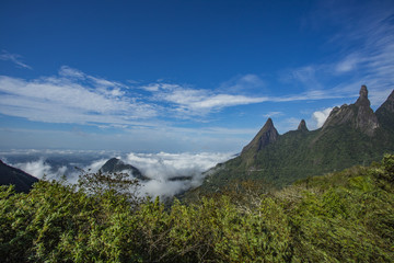 Stunning scenery at sunset in the Brazilian mountains with clouds covering the valley below.  Fog and mist covering the valleys below, autumnal landscape, cold feeling. 