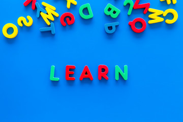 Children learn read concept. Word learn written by plastic letters on blue background top view copy space