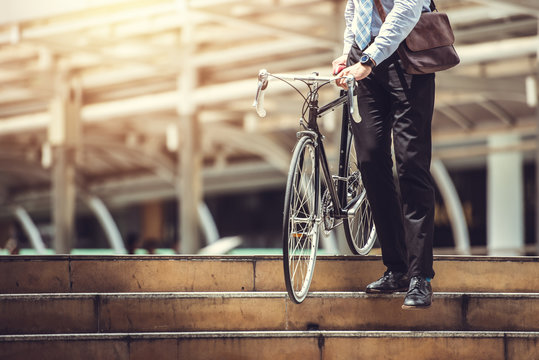 Smart Businessman Holding Bicycle goto Work on Urban Sidewalk in Rush Hour  - Eco Friendly and Lifestyles Concept