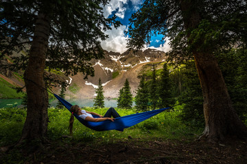 Girl rests on a Hammock looks at Dallas Peak near Lower Blue Lake Ridgway Colorado