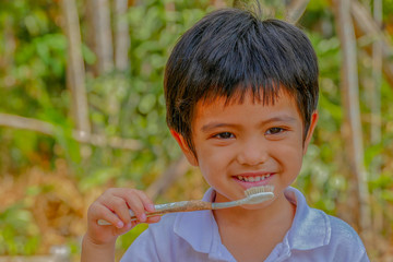 Asian little boy show dirty toothbrush