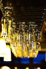 Glasses on a bar hanging upside down. The bar counter in the cafe