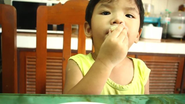 Thai child eating food on the table