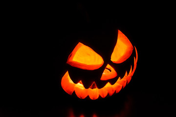 Fototapeta premium Spooky halloween pumpkin on a black background