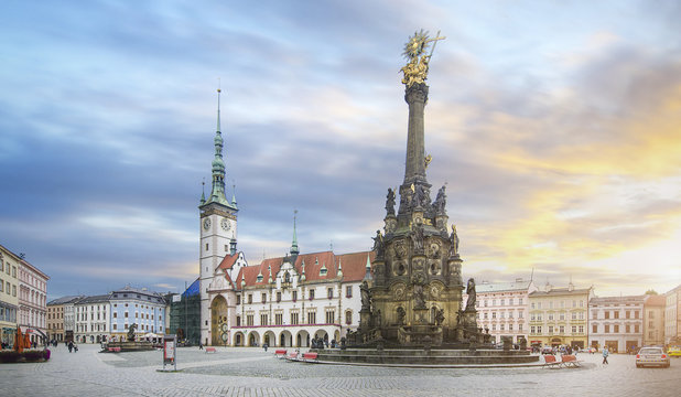 Panorama of the Square and the Holy Trinity Column enlisted in the Unesco world heritage list and Astronomical clock in the building of the Town Hall in Olomouc, Czech Republic at sunset