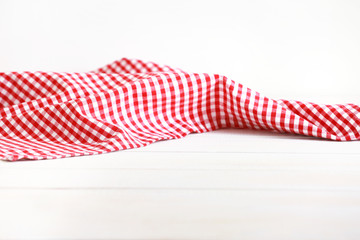 Red picnic cloth on wooden background.