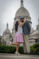 Paris, France - 10 07 2018: Montmartre. Photo shoot in Montmartre outdoor at Citadin Park. Female and male model, Sophie Marc and Bastien Rieu, with the Sacred Heart in the background