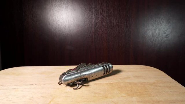 Old dirty broken multi tool knife set open isolated indoors on wooden table