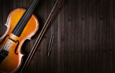 violin bow and tuning forks on a dark wooden background