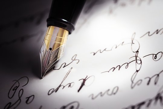Fountain pen on top of a letter written in cursive