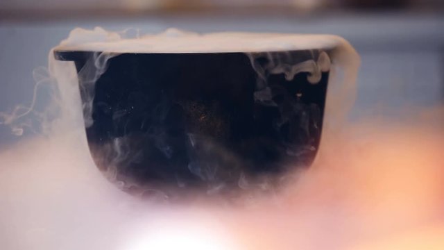 Magical potion bubbling in witch cauldron with white smoke, Halloween witchcraft