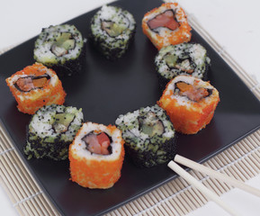 Sushi Set - different types of Maki sushi and chopsticks on a b