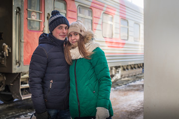 Couple at railway station near train in a winter time