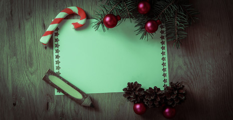 blank Christmas card and ornaments on wooden background.