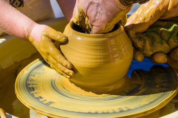hands of the skilled master Potter and children's hands, training of the kid to production of pottery on a Potter's wheel