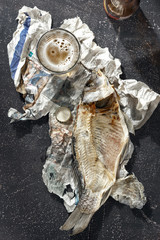 Dried fish beer dark blue background top view