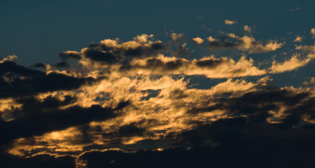 Dramatic sunset sky with orange colored clouds.