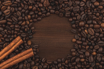 Roasted coffee beans and cinnamon sticks. Background, close-up view.