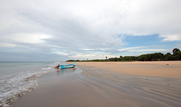 Nivali beach with boat and streaky sand patterns in Trincomalee Sri Lanka Asia