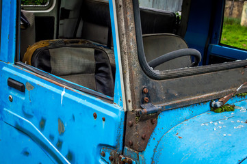 Abandoned vintage car blue lush green grass steering car interior damaged seats