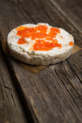 Rice crackers with smoked salmon spread on old wooden surface