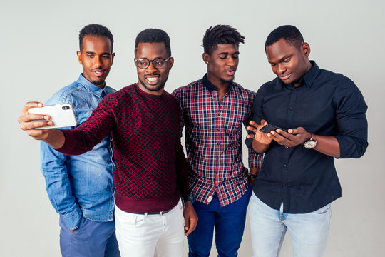 four blogger funny friends afro american men taking selfie in studio on white background