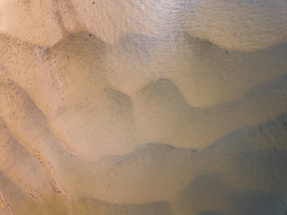 The sand as the tide moves it around creating patterns and shapes