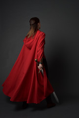 full length portrait of brunette girl wearing red medieval costume and cloak. standing pose  with...