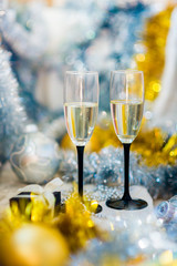 couple.  glasses with sparkling white wine on the background of a New Year's shiny decor