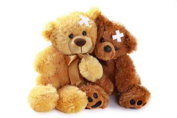 Two Teddy Bears with Crossed Adhesive Bandages on Head