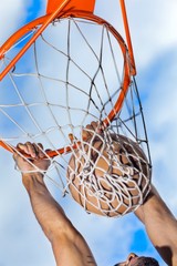 Hanging on Basketball Hoop After Slam Dunk Close-Up © BillionPhotos.com