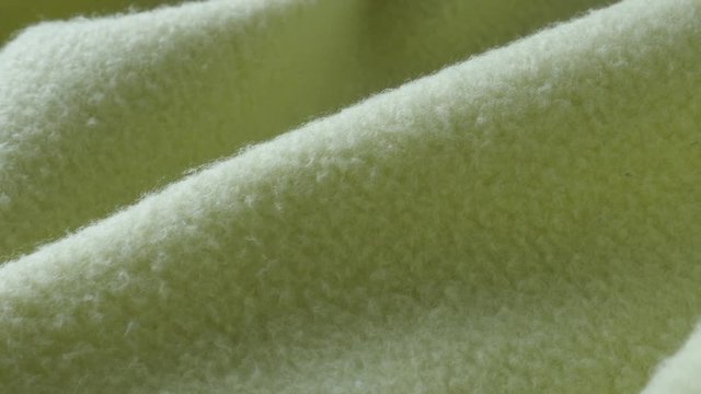 Close-up panning over surface of green polar fleece blanket 4K footage