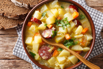 Slow cooker German potato soup (kartoffelsuppe) close-up on a plate. Horizontal top view from above