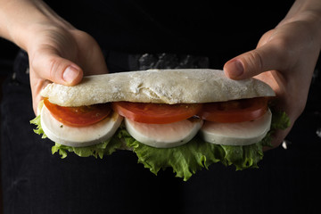 caprese sandwich in woman's hands
