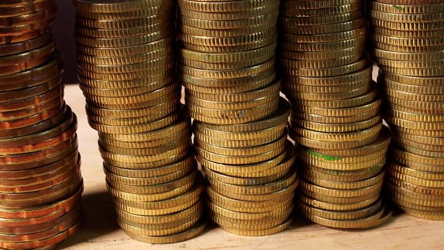 Stacks of Gold Coins isolated indoors on wooden table