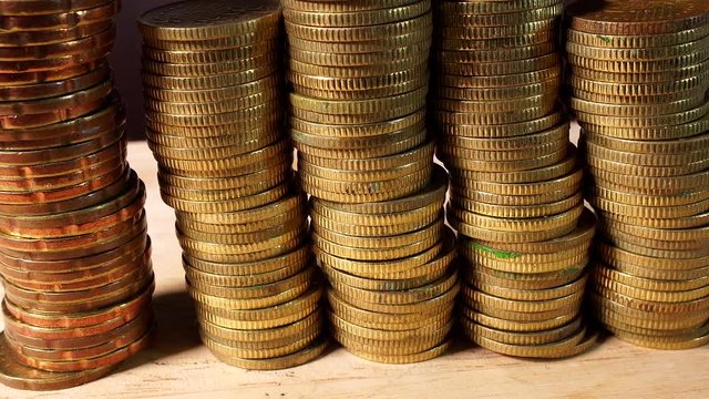Stacks of Gold Coins isolated indoors on wooden table