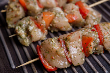 Skewers with raw meat on grill pan
