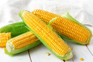 Raw corn on a wooden table